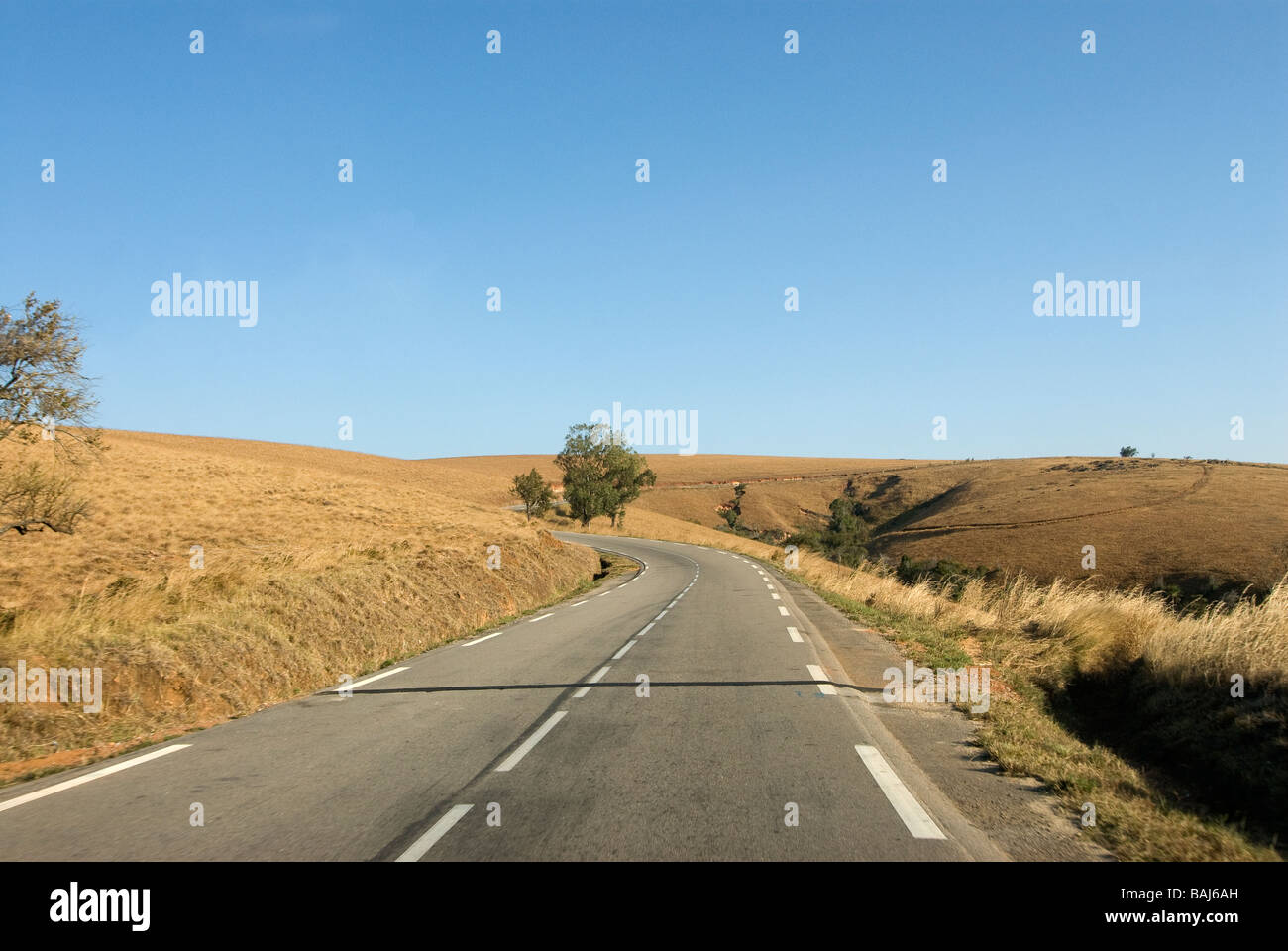 Strada che conduce attraverso la savana paesaggio del Madagscar Africa Foto Stock