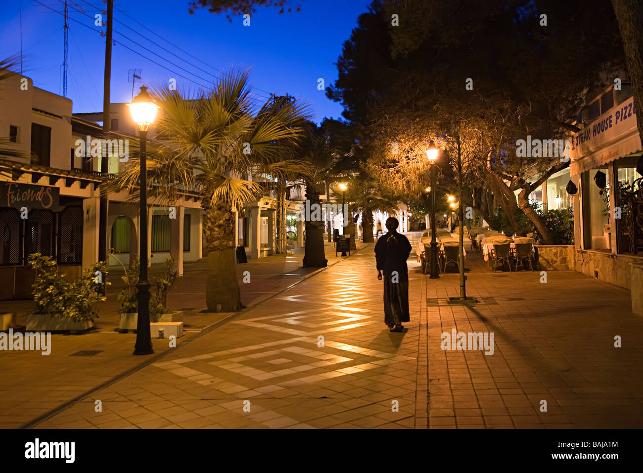 Unica donna a piedi di notte attraverso il villaggio turistico Cala d'Or Mallorca Spagna Spain Foto Stock