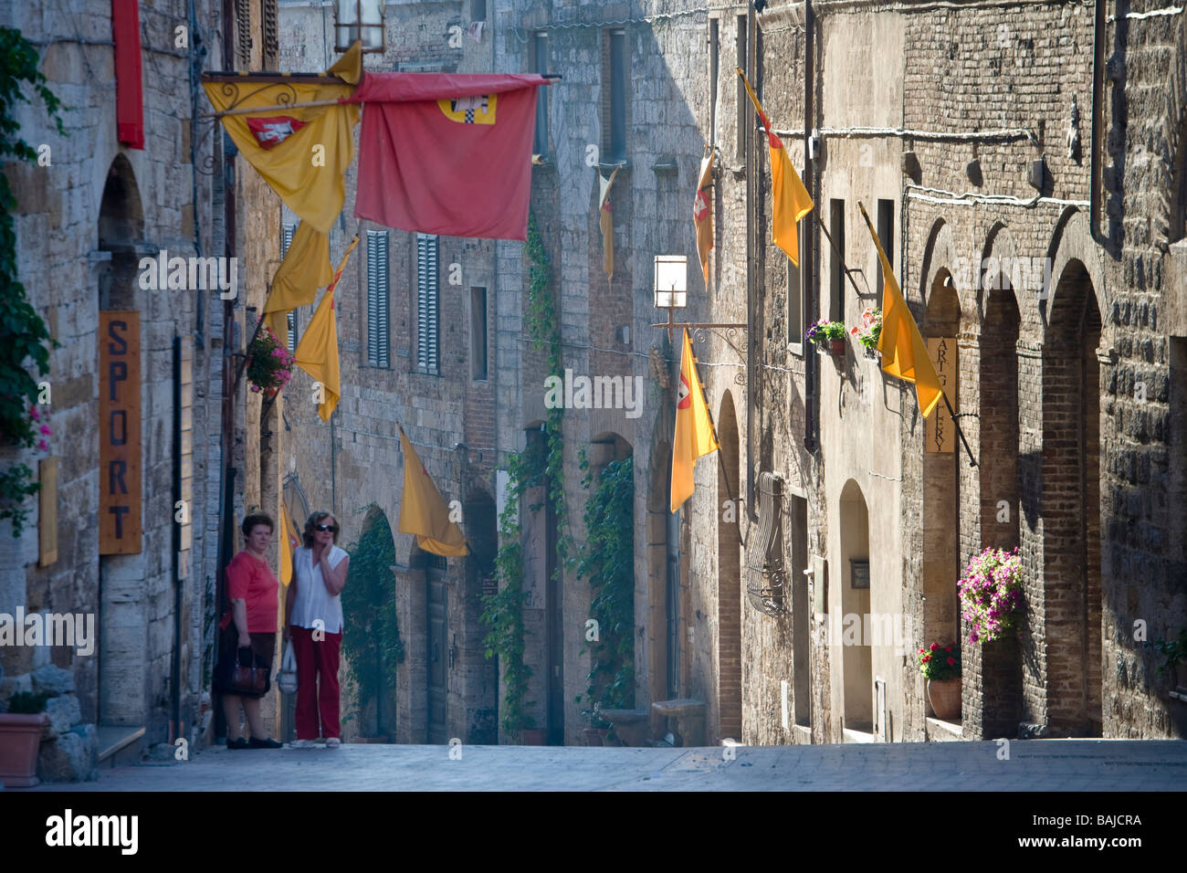 Due donne in strada all'alba a San Gimignano, Toscana, Italia Foto Stock