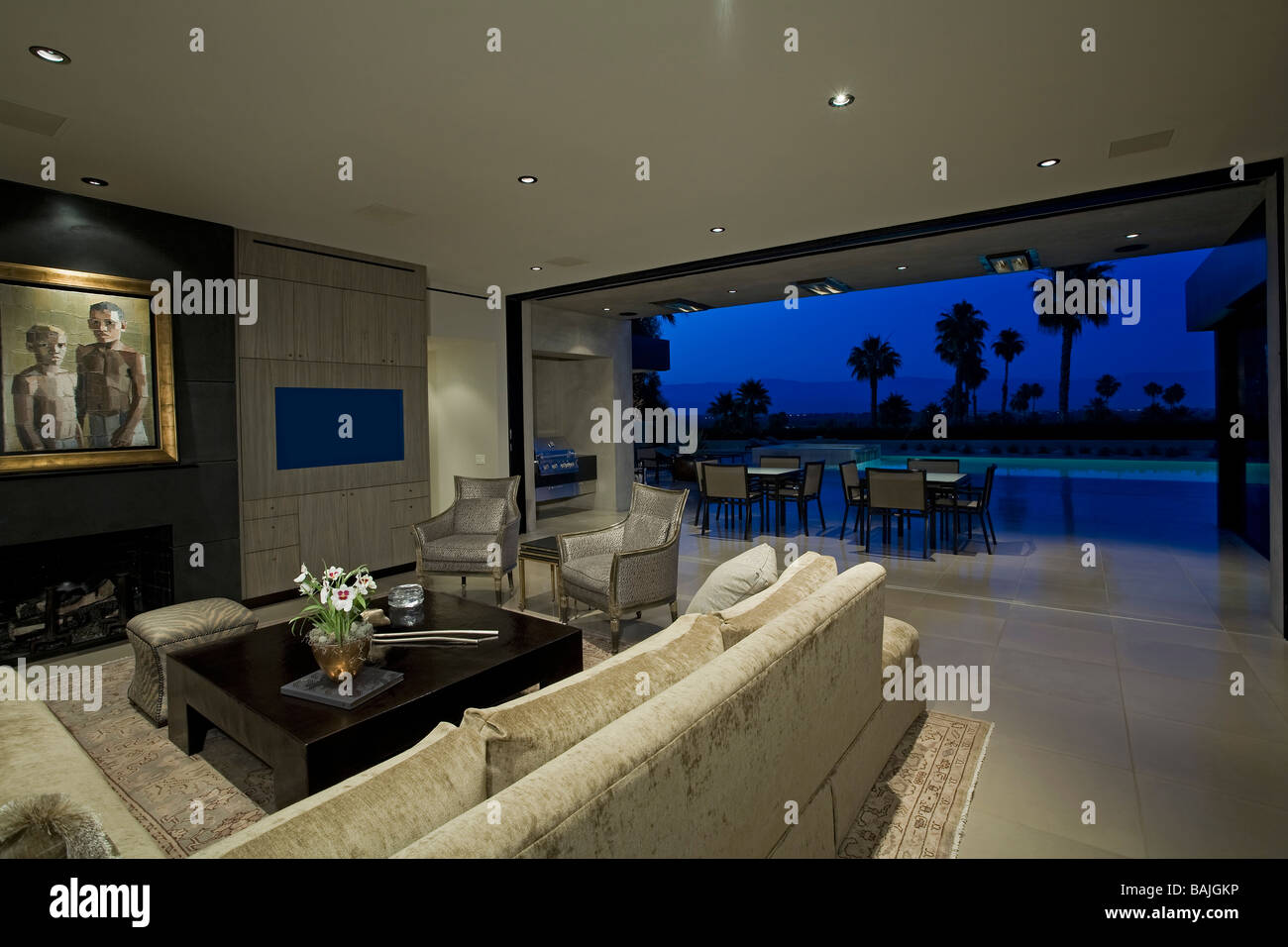 Interni di lusso con vista della piscina e patio, crepuscolo Foto Stock