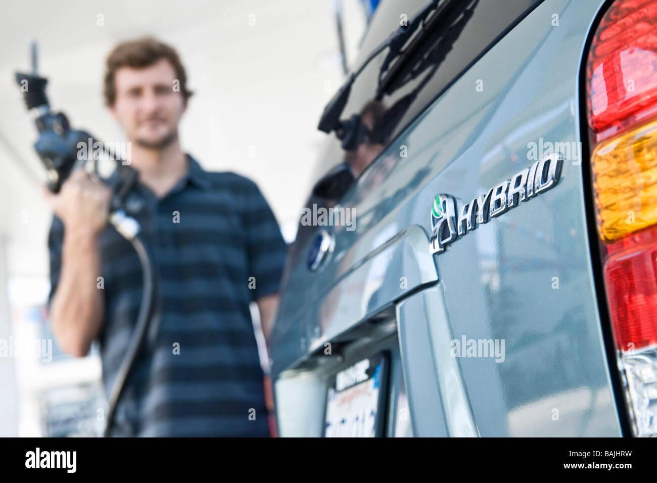 L'uomo il rifornimento di carburante di automobili ibride Foto Stock