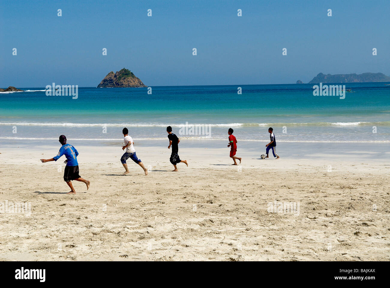 Indonesia, Lombok, a sud di Lombok, Selong Blanak spiaggia vicino a Kuta, giovani giocando con una sfera Foto Stock