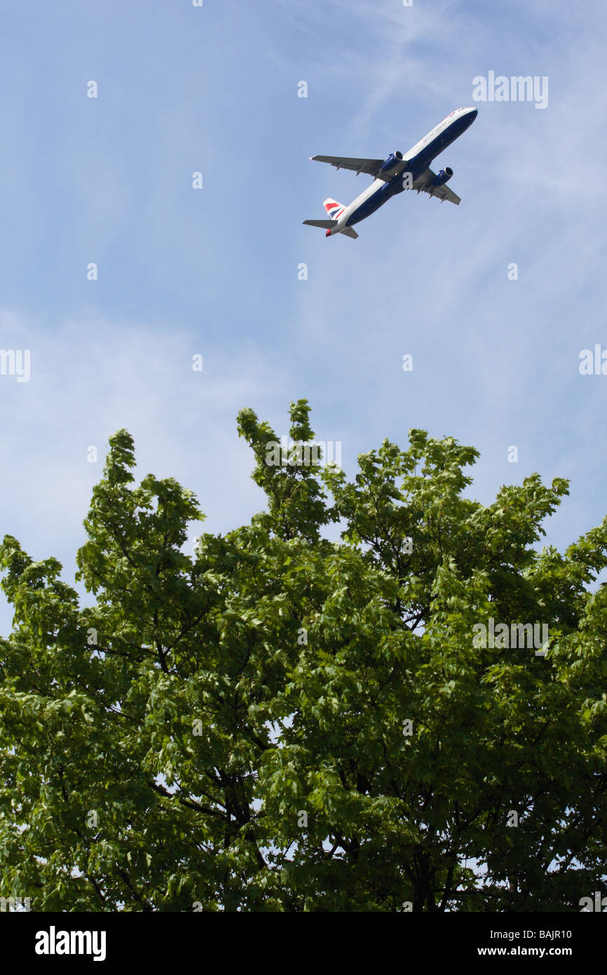 British Airways jet aereo sopra un albero verde top come foglie London Heathrow Foto Stock