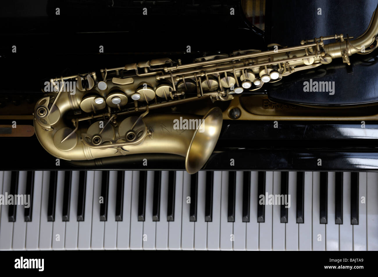 Alto sassofono giacente su un pianoforte a coda Foto Stock