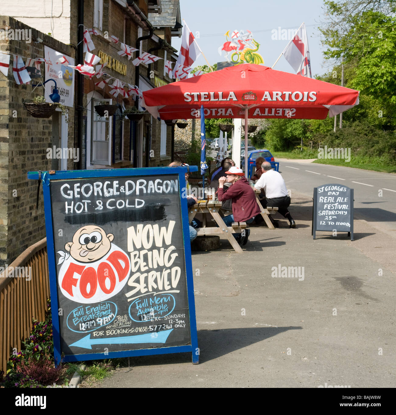 Le persone a bere birra al di fuori del George and Dragon pub, su St Georges giorno, Snailwell, Cambridgeshire Regno Unito Foto Stock
