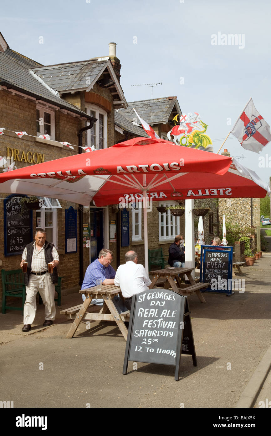 Le persone a bere birra al di fuori del George and Dragon pub, su St Georges giorno, Snailwell, Cambridgeshire Regno Unito Foto Stock