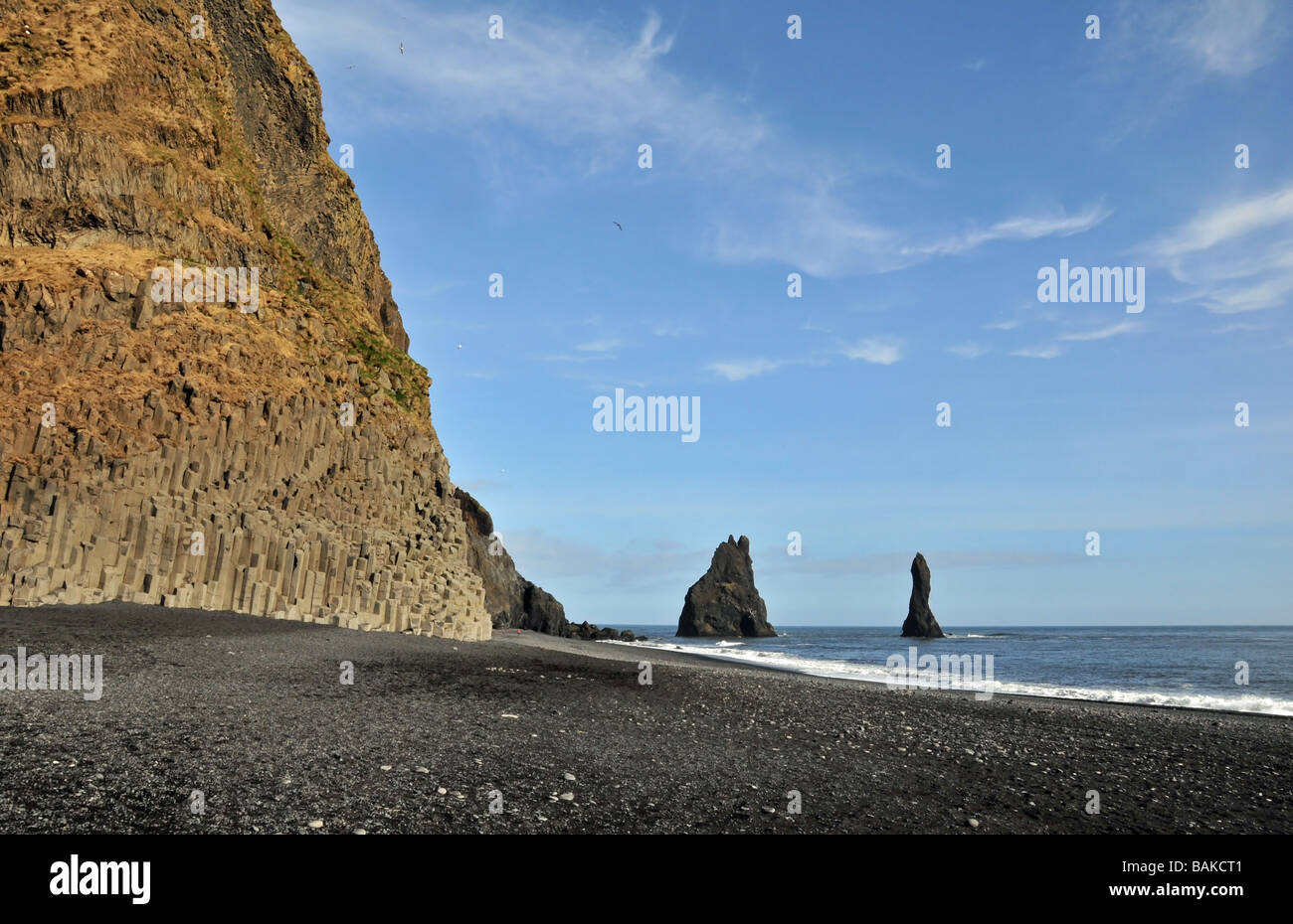 Vista costiera a Reynishverfi, vicino Gardar, Sud dell'Islanda, delle sabbie nere, colonne di basalto e il mare di pile a Reynisdrangur Foto Stock