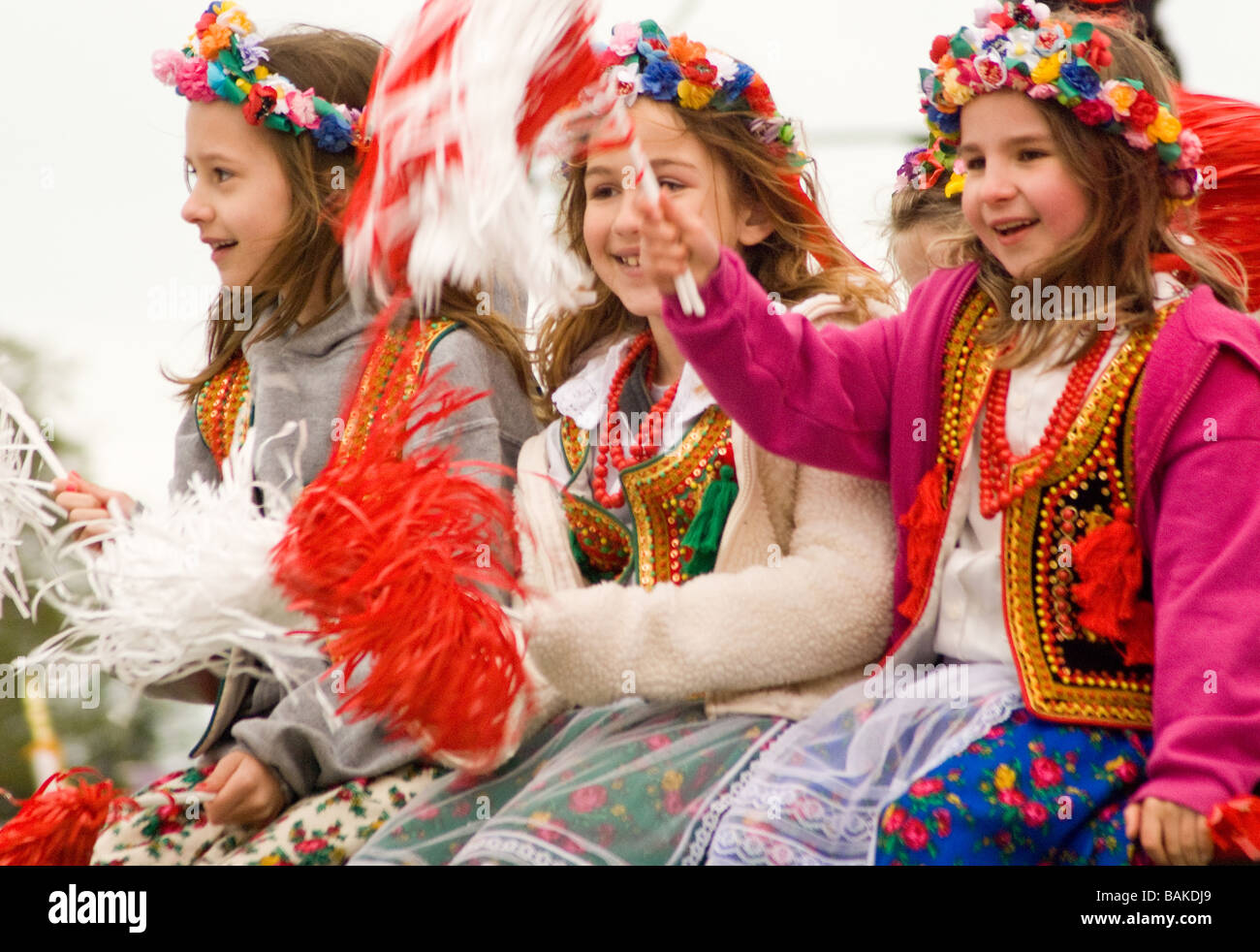 Tre ragazze sorridenti a cavallo di un onda di flottazione pom pom in Chicago parata polacco Foto Stock
