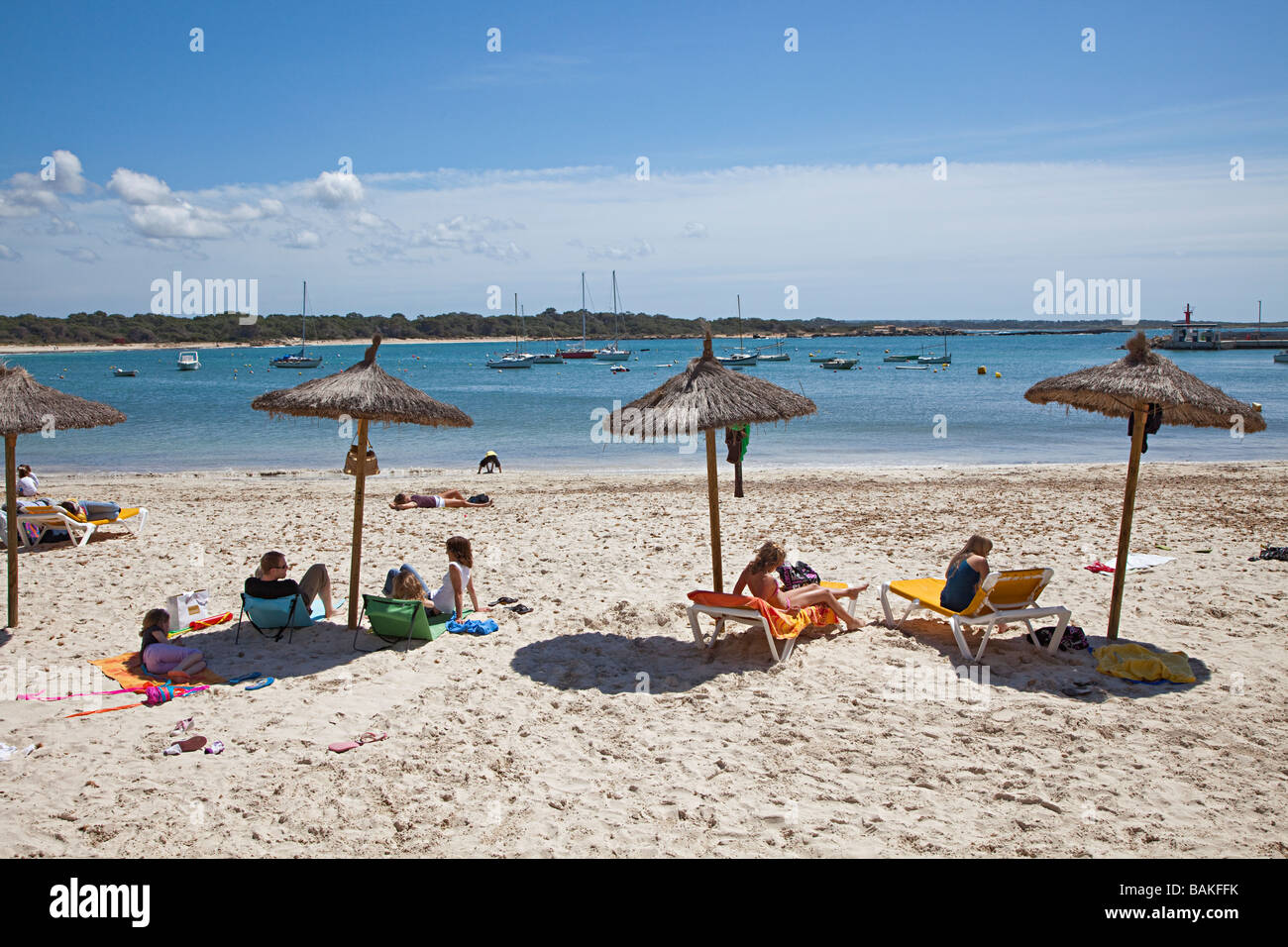 Persone sotto l'ombra ombrelloni sulla spiaggia Colonia de Sant Jordi Mallorca Spagna Spain Foto Stock