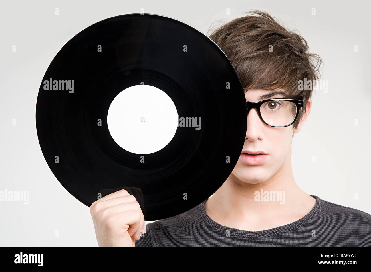 Un ragazzo adolescente tenendo un disco in vinile Foto Stock
