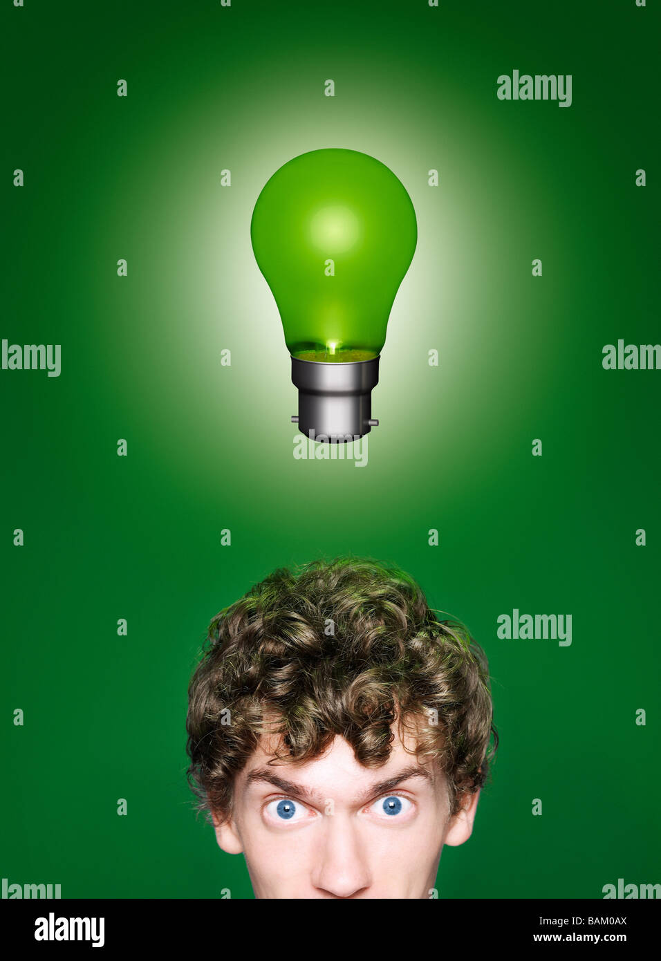 Un giovane uomo con una lampadina verde sopra la sua testa Foto Stock