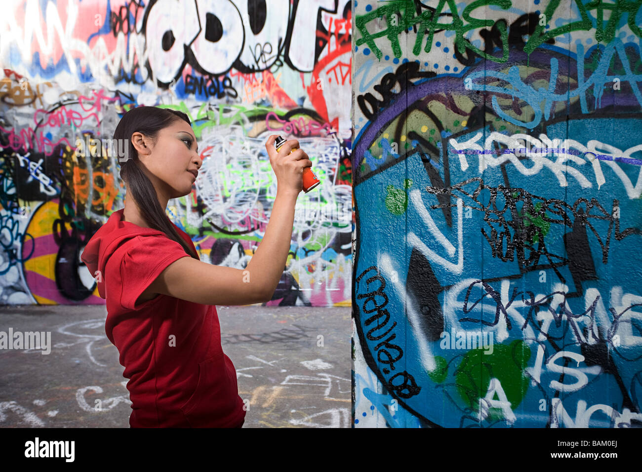 Una giovane donna graffiti di spruzzatura Foto Stock