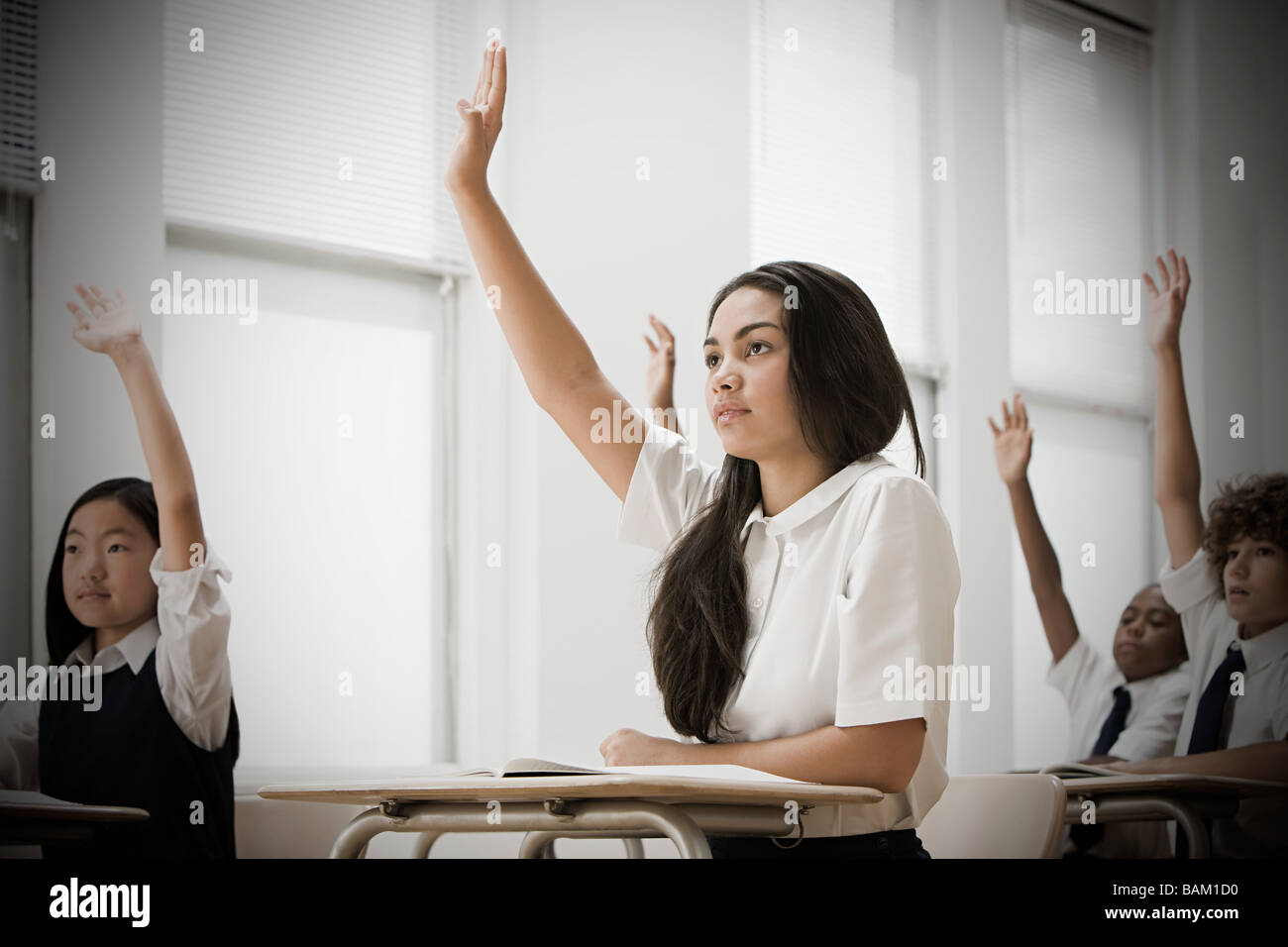 Gli studenti della scuola con le mani alzate Foto Stock