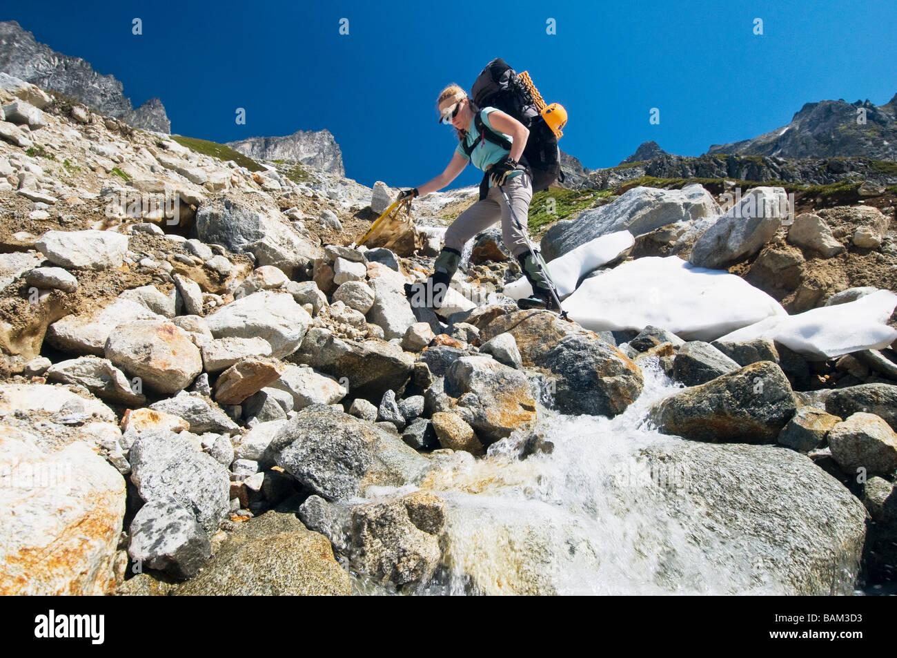Una giovane donna scalare una montagna Foto Stock