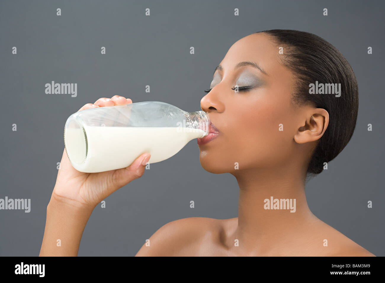 Donna di bere una bottiglia di latte Foto Stock