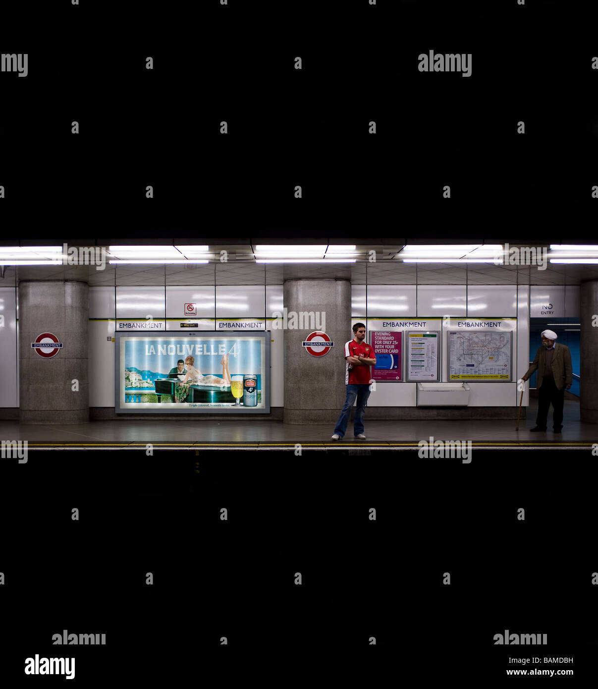 Due persone in piedi sulla piattaforma al terrapieno la stazione della metropolitana di Londra. Foto di Gordon Scammell Foto Stock