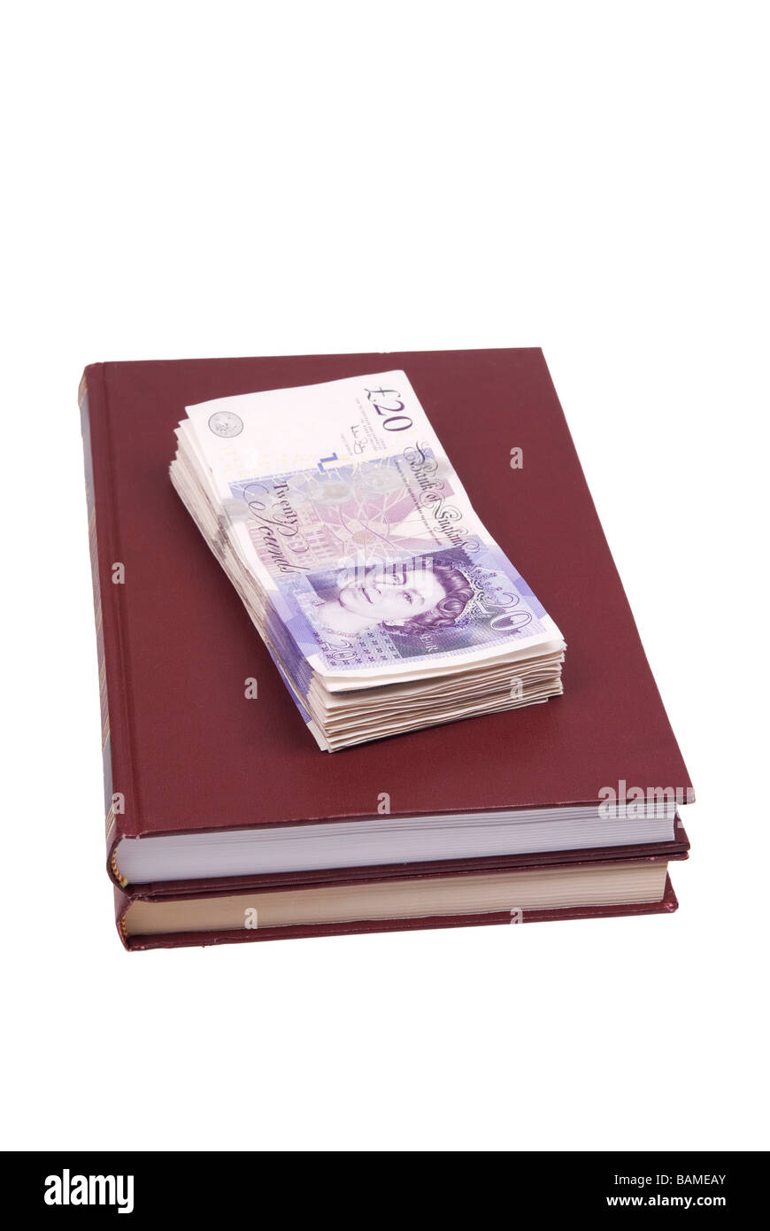 Pila di denaro britannico sulla parte superiore dei libri Foto Stock