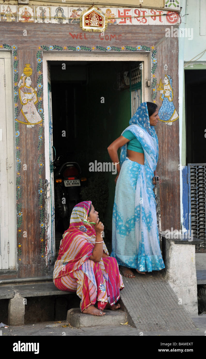 Le donne in Colorati luminosamente sari in piedi in un portale decorato in Udaipur, India Foto Stock