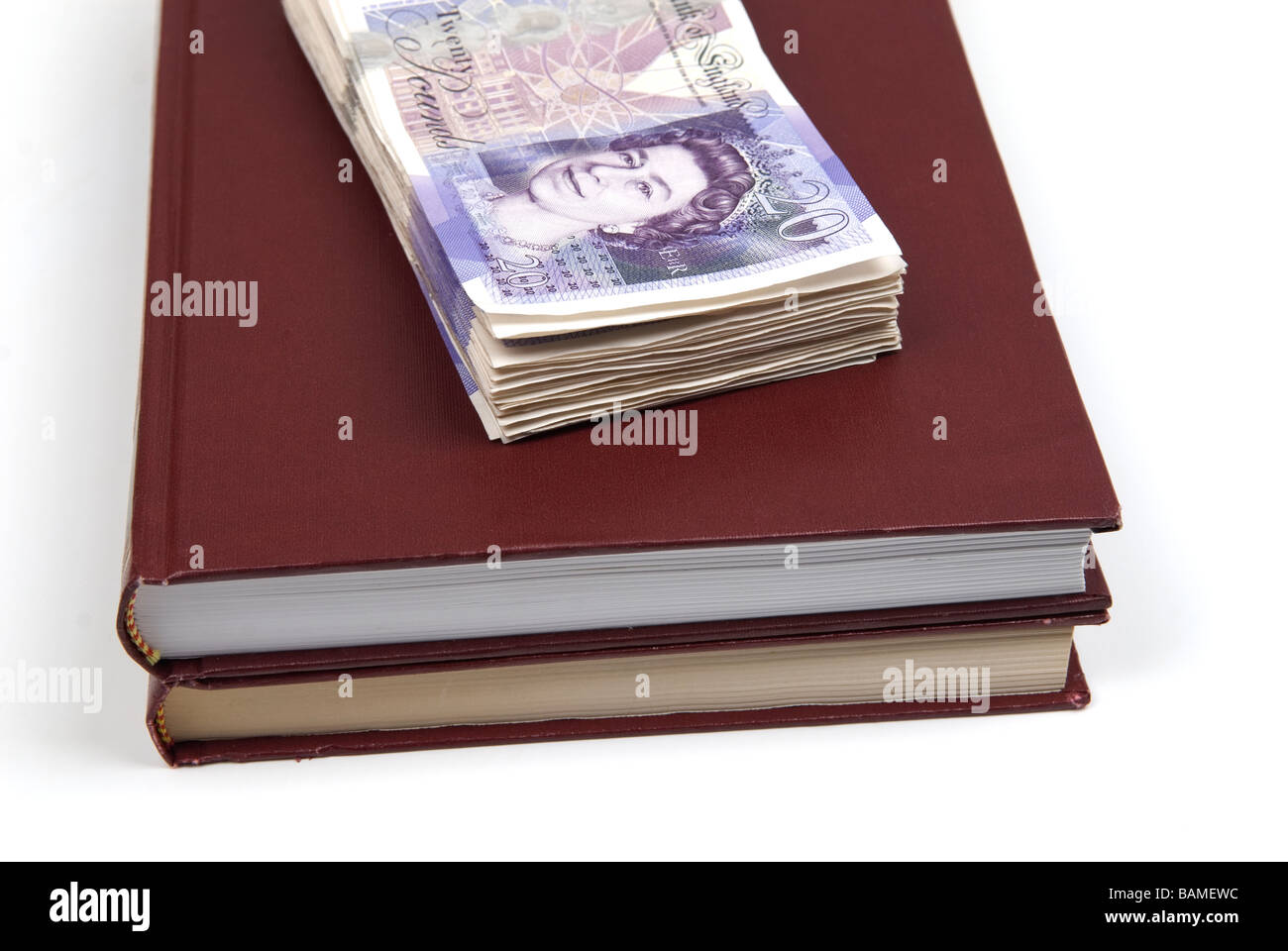 Pila di denaro britannico sulla parte superiore dei libri Foto Stock