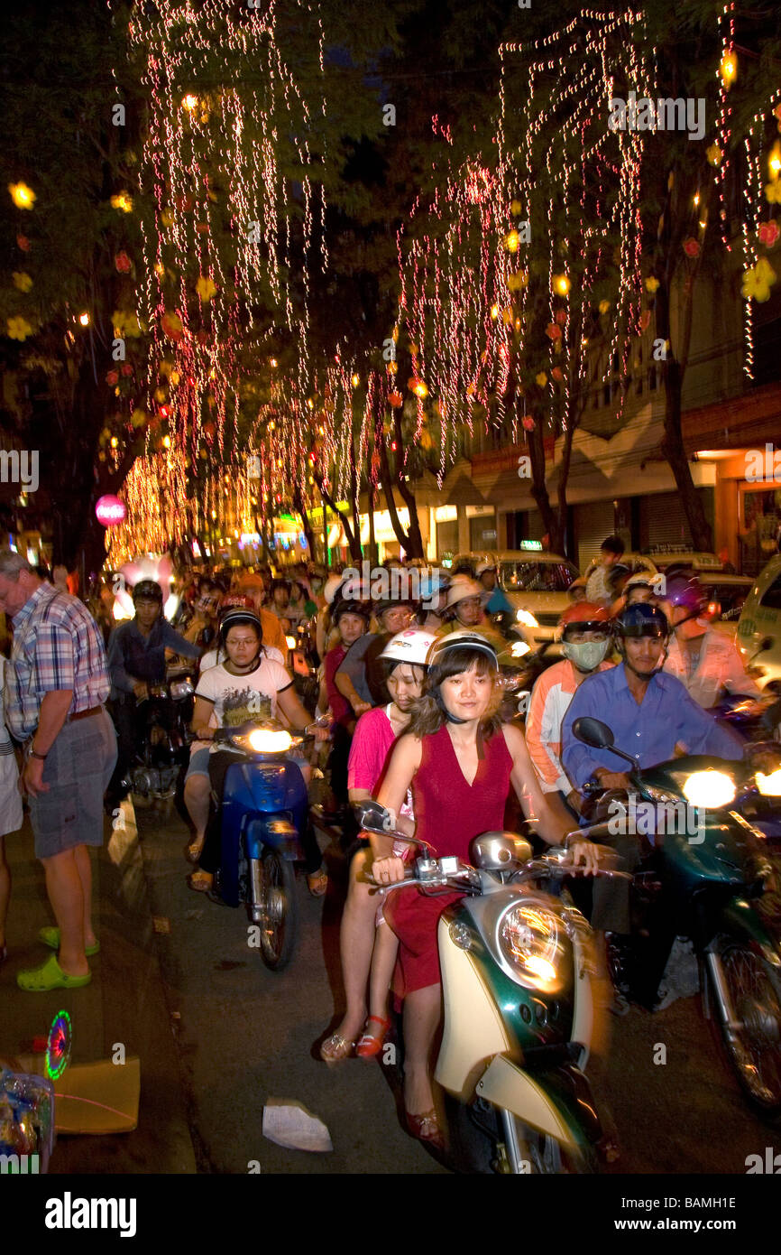 Popolo vietnamita cavalcare le motociclette su Dong Khoi street l ultima notte del Tet celebrazioni in Ho Chi Minh City Vietnam Foto Stock