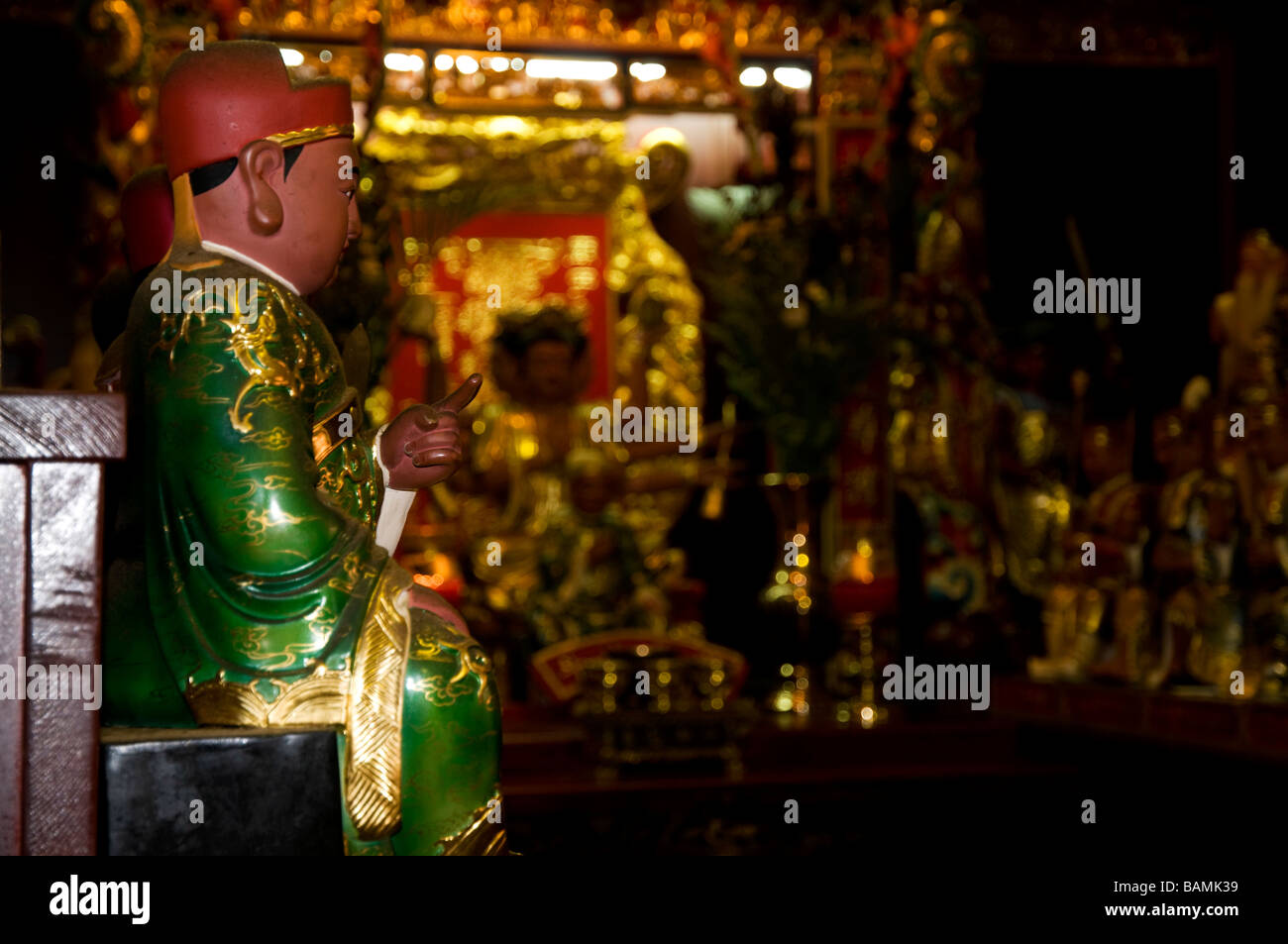 Piccola statua del vestito di verde manto e puntare il dito divinità in un tempio buddista di Sanxia (Sansia) in Taiwan Foto Stock