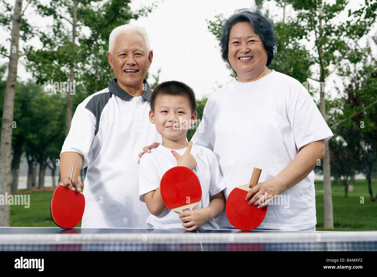 Nonni e nipote giocando a ping pong Foto Stock