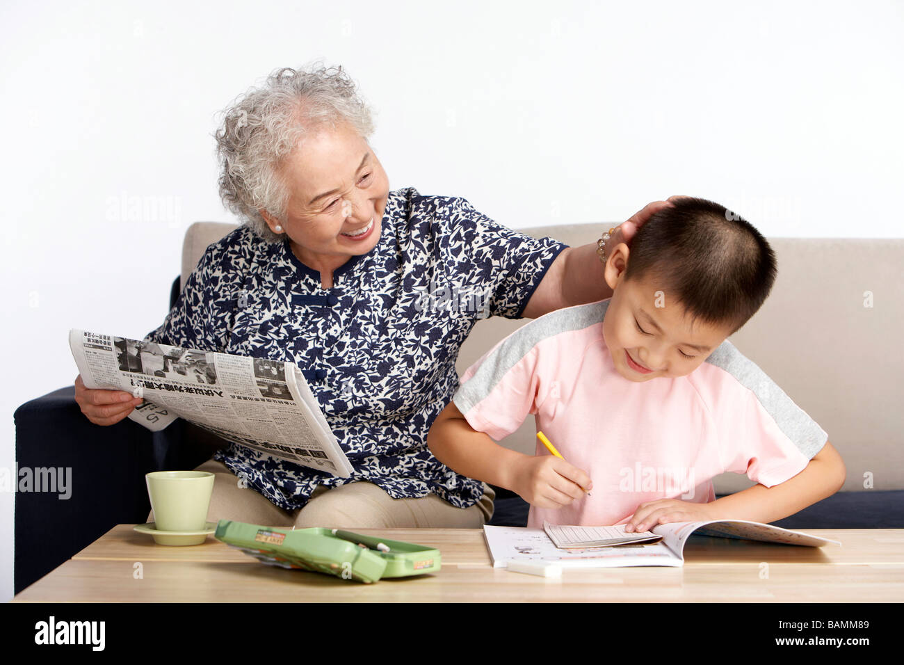 Nonna lodando nipote che è quello di imparare a scrivere Foto Stock