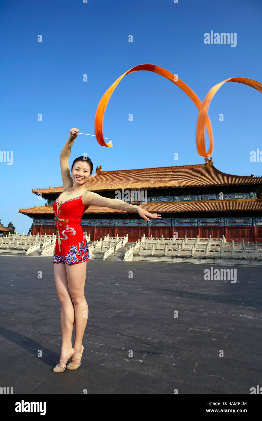 Giovane donna danza a nastro nella parte anteriore di un tempio Foto Stock