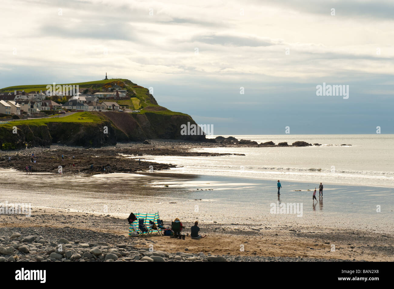 La gente sulla spiaggia vicino alle scogliere sul mare a Borth Ceredigion West Wales UK Foto Stock
