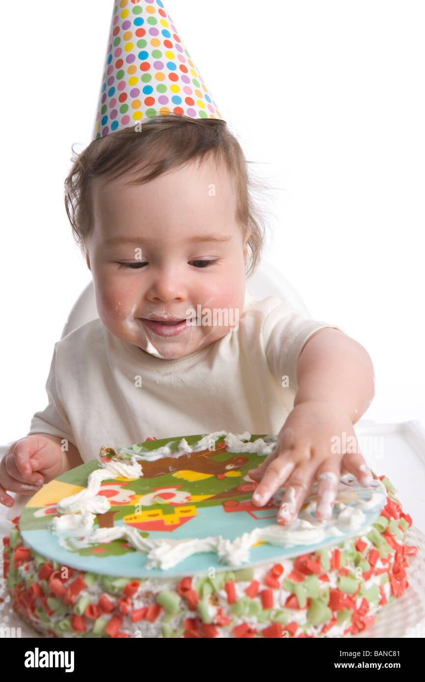 Un anno vecchia ragazza con party hat e torta di compleanno Foto Stock