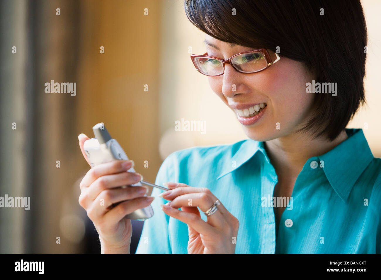 Donna asiatica sorridente e utilizzando Organizer elettronici Foto Stock