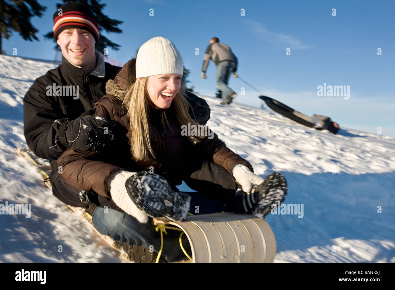 Sport invernali; giovane toboga discesa lungo un pendio Foto Stock