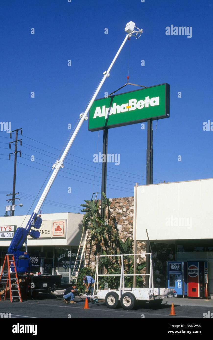 Sollevamento gru segno alfa beta market store negozio di generi alimentari in acciaio alto alto installare ad opera di saldatura logo rettangolare Foto Stock