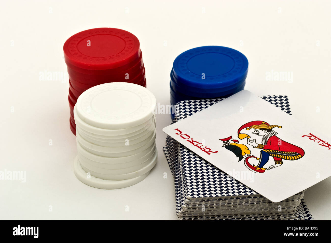 Mazzo di carte da gioco accanto a tre pile di poker chips Foto Stock
