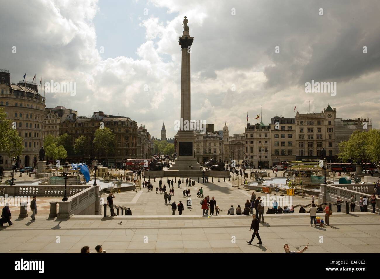 Nelson la colonna con i turisti in Trafalgar Square, Londra e nuvole temporalesche tettuccio Foto Stock