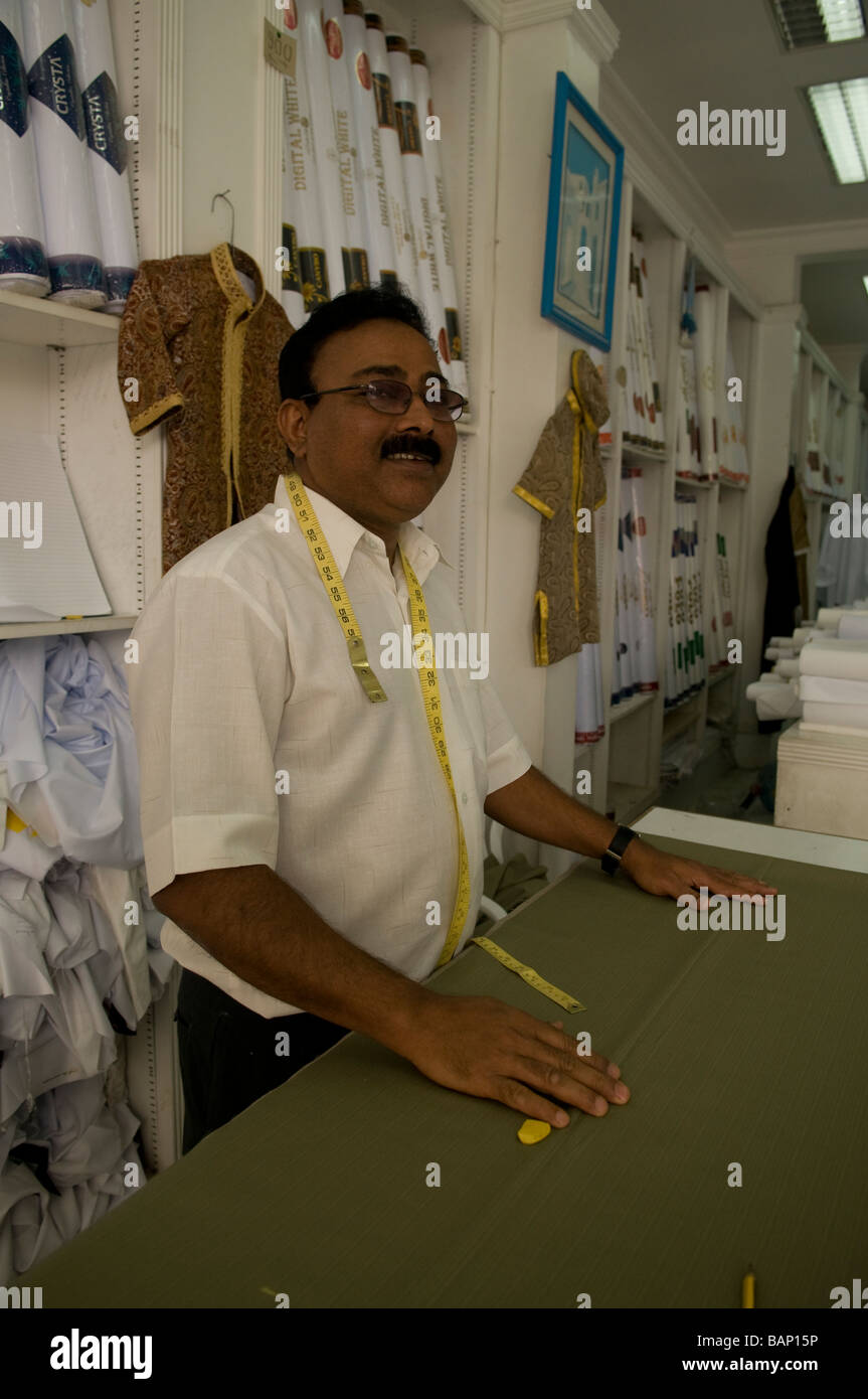 Sarto indiano in Qatar presso il suo contatore, nel suo negozio in un centro città souq di Doha Foto Stock