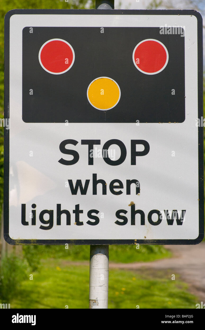 Stazione ferroviaria di passaggio a livello Stop quando le luci visualizza il traffico stradale segno cartello stradale Regno Unito Foto Stock