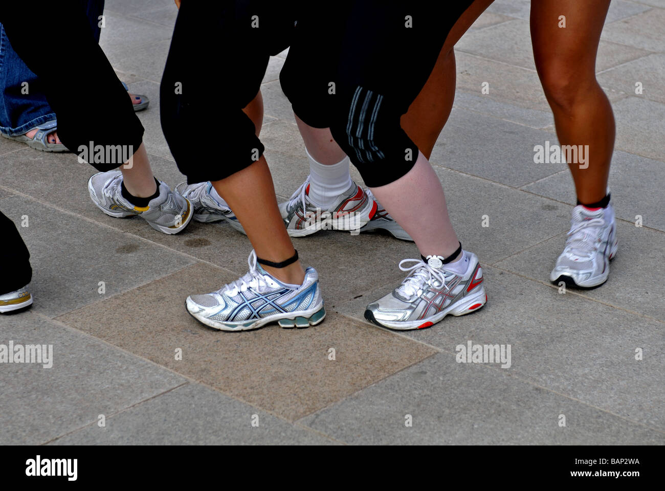 Le ragazze che indossano i formatori e i chip alla caviglia, REGNO UNITO Foto Stock