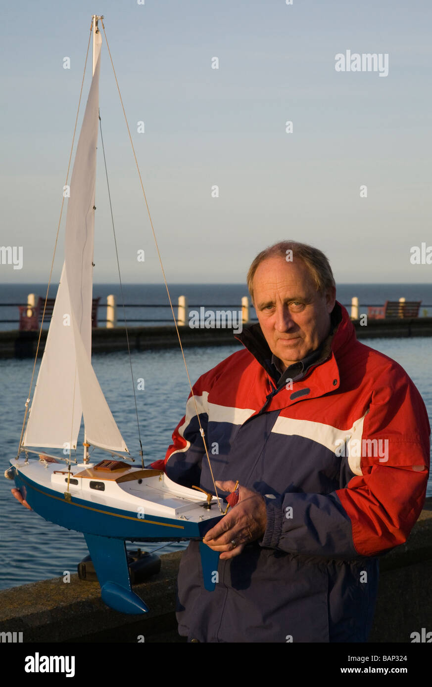 Un uomo con la sua radio controlled yacht Foto Stock