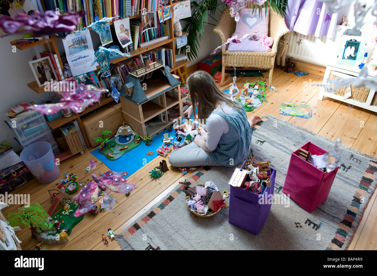 Un bambino gioca con la loro casa delle bambole nella loro camera da letto Foto Stock