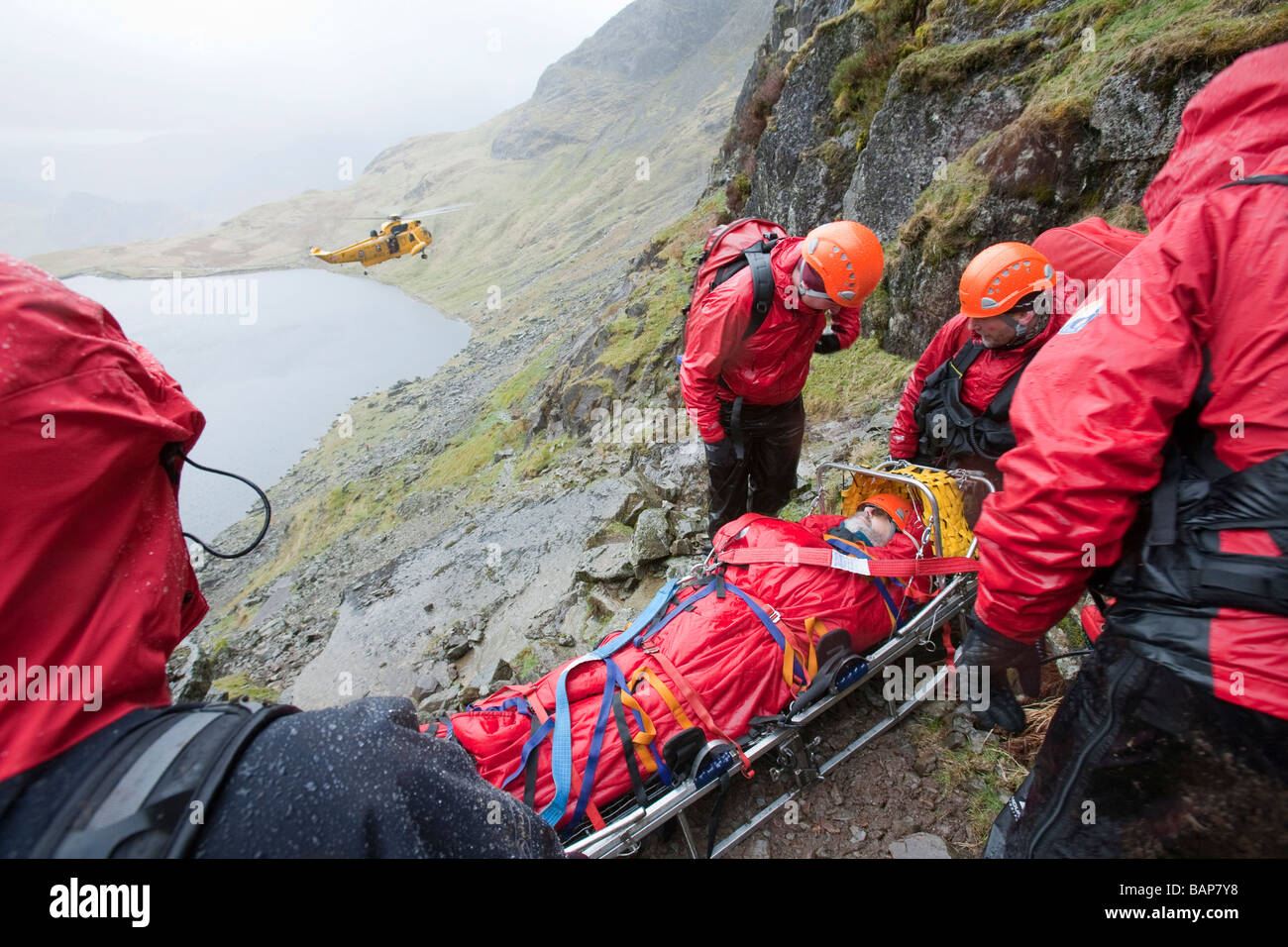 Un viandante con un composto di frattura della gamba viene trattata da Langdale Ambleside Mountain Rescue Team in facile canalone su Pavey Ark Foto Stock