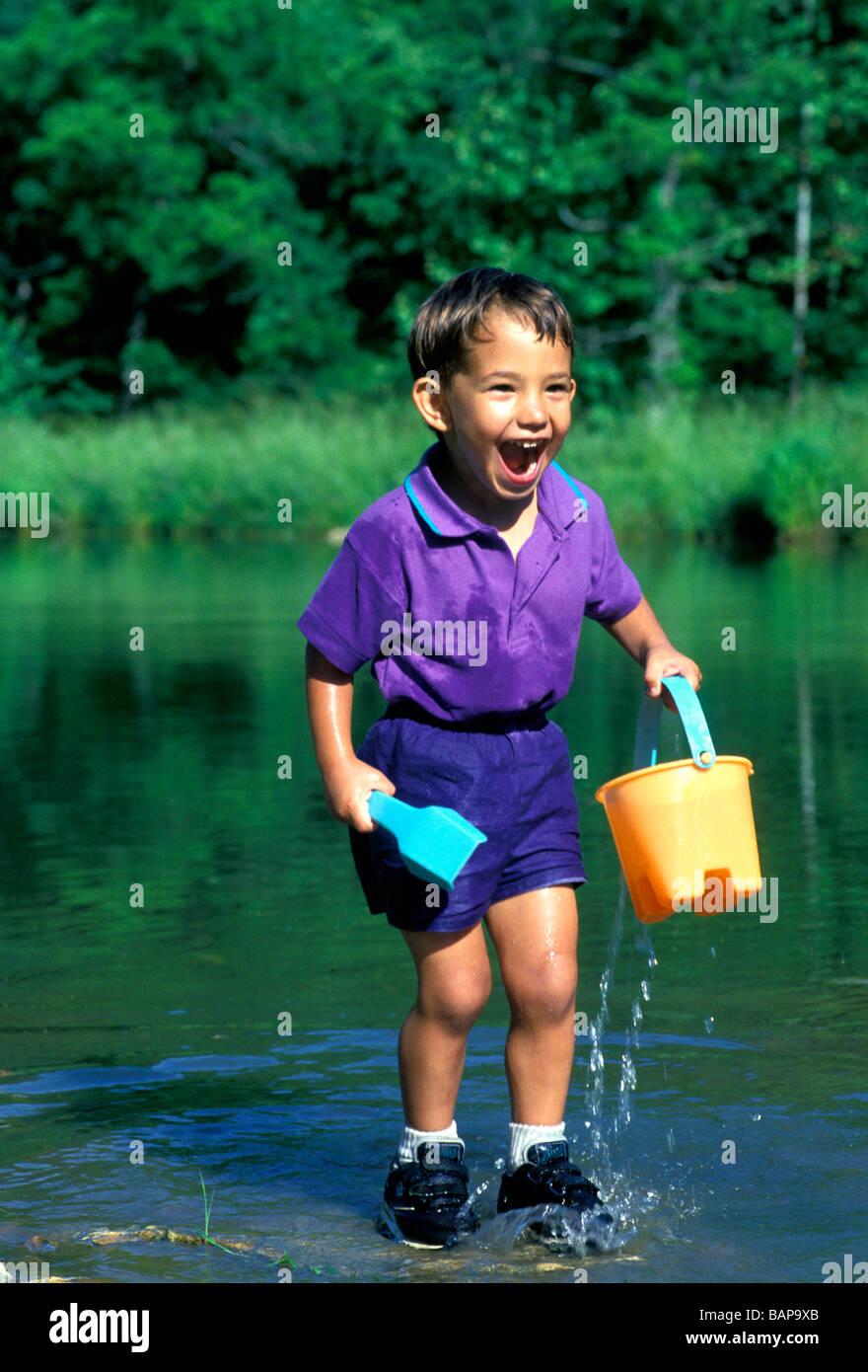 Giovane ragazzo Afghan-American eccitato e felice con giochi d'acqua Foto Stock
