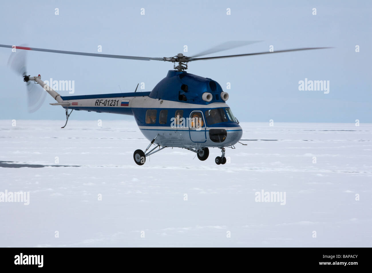 Close-up hovering profilo elicottero tour aria volando sopra la banchisa che trasportano i turisti in Antartide, fotografo con la fotocamera nella finestra Foto Stock