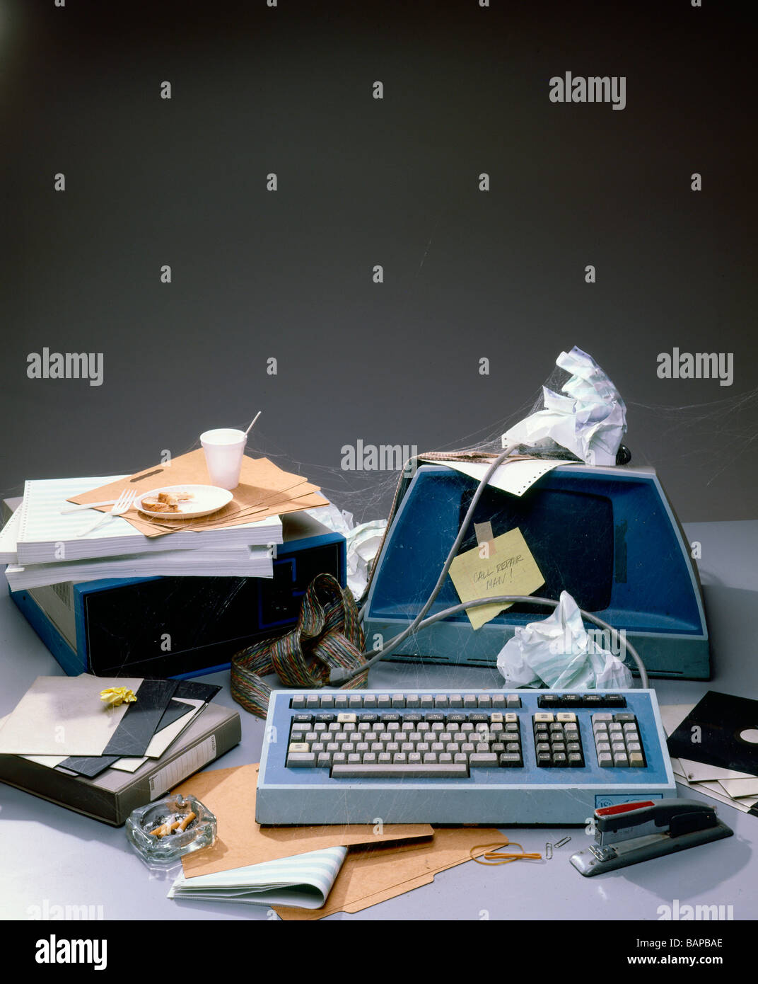 Un desktop abbandonati cosparso di materiale informatico obsoleto e cestino Foto Stock