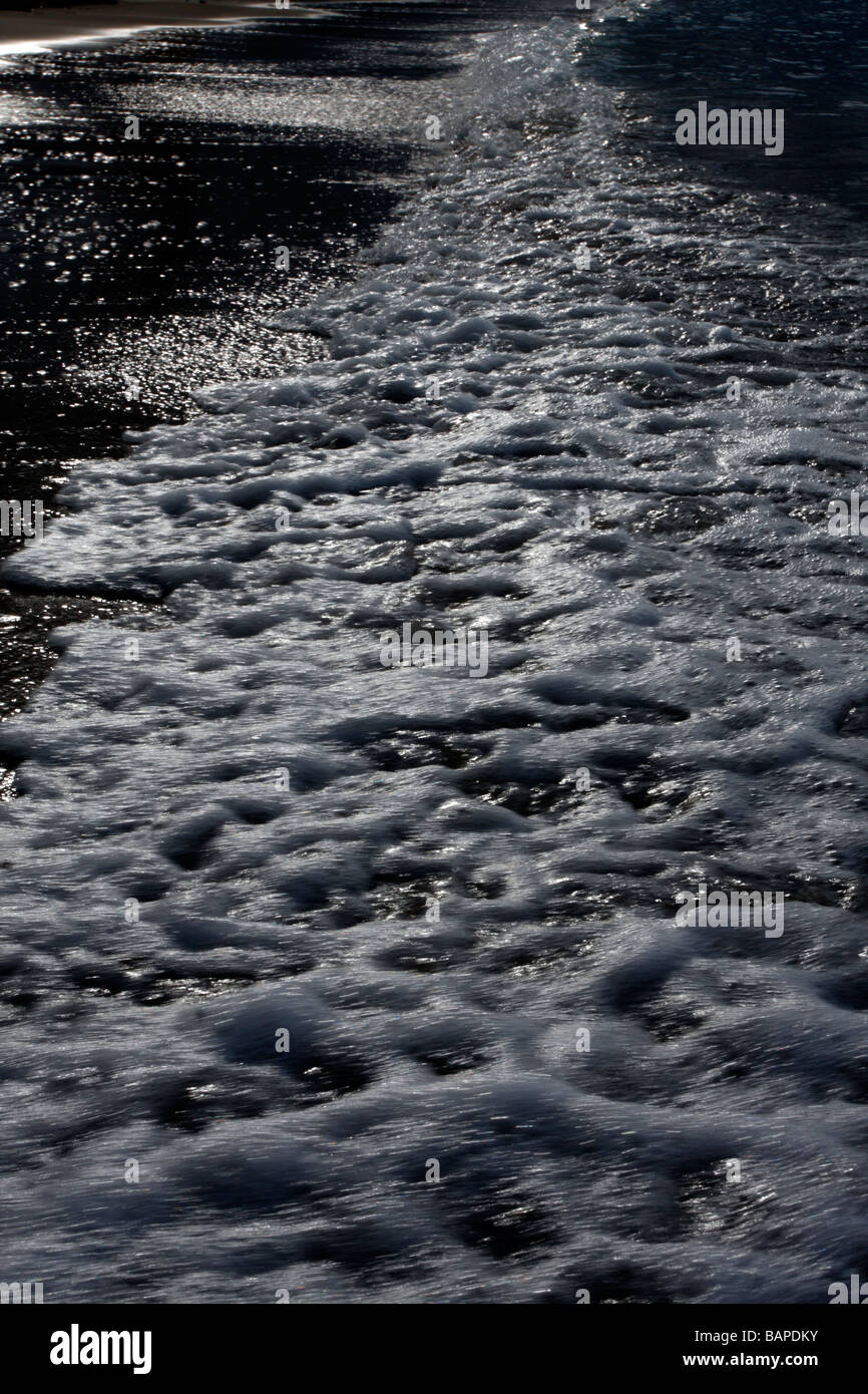 Onde e schiuma sulla spiaggia di Runaway Bay, Giamaica Foto Stock