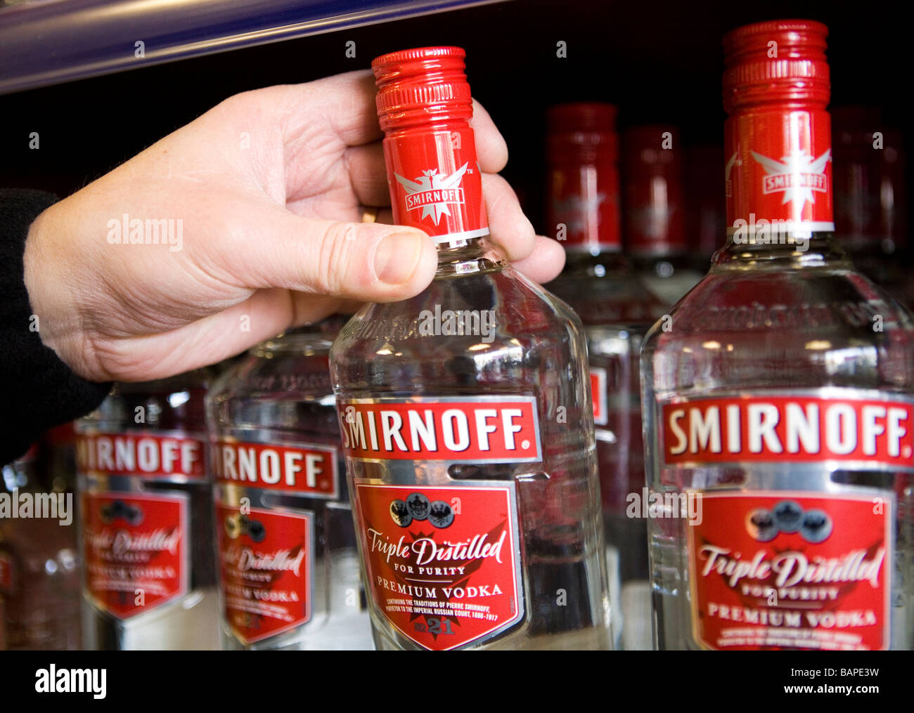 Bottiglie di Smirnoff vodka sul ripiano in una licenza off Foto Stock