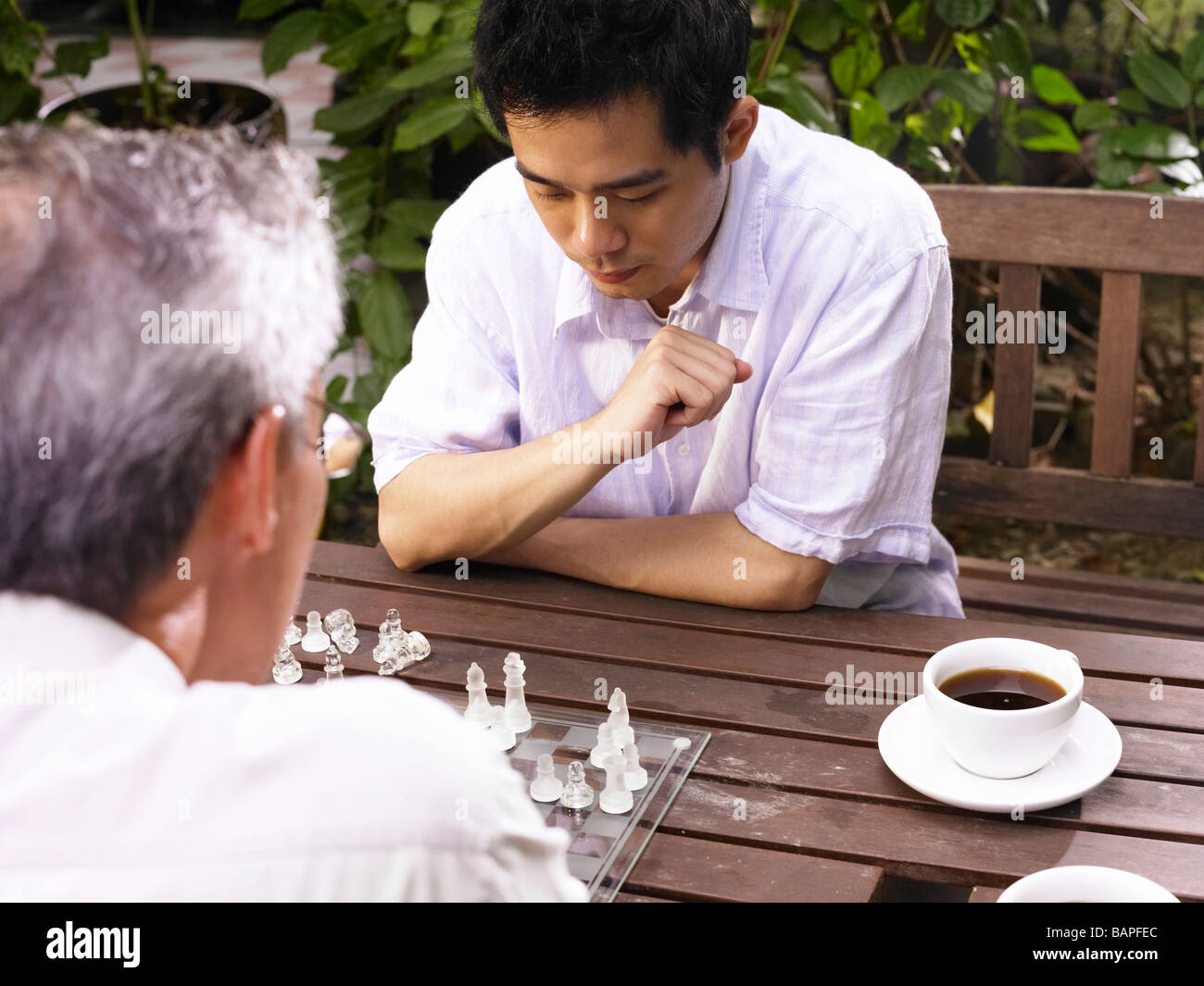 Padre e figlio giocare gioco di scacchi in giardino Foto Stock
