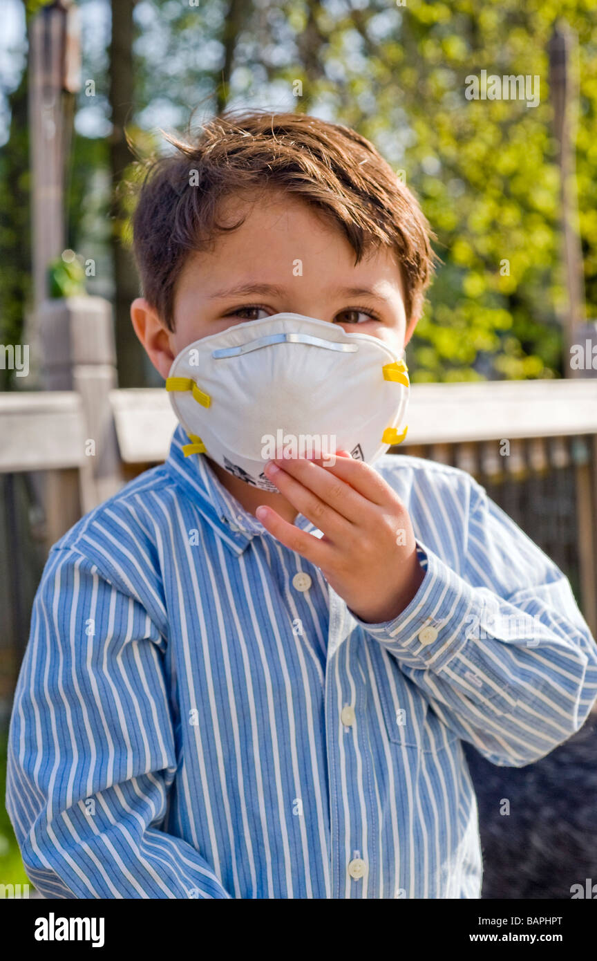 Tre e 1/2 anno vecchio ragazzo ispanico indossa un N95 nominale maschera Respiratore di protezione contro l'influenza suina Foto Stock