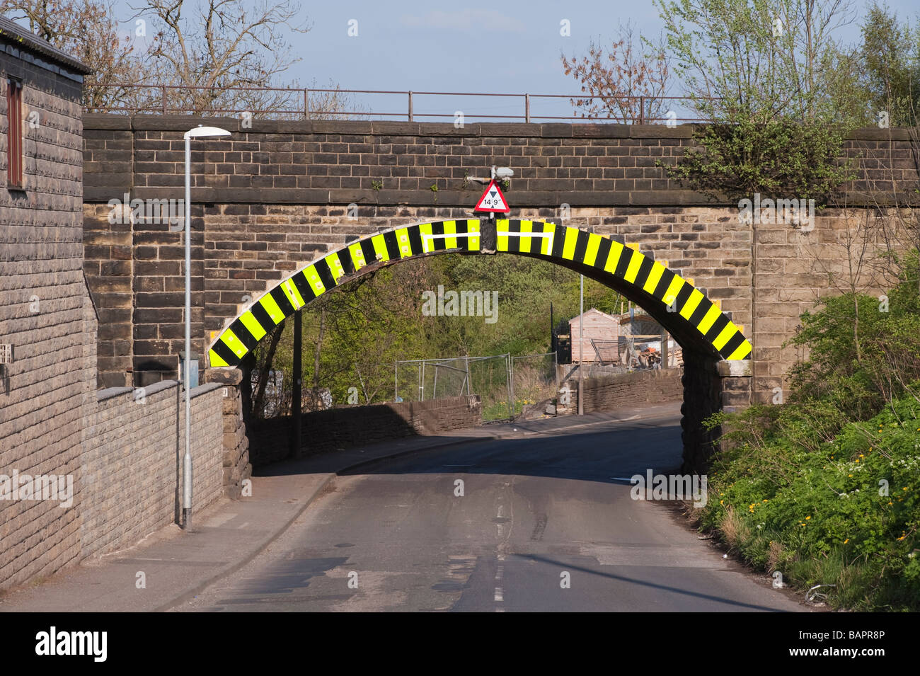 Bassa roadbridge con il giallo e il nero a strisce marcature di avvertimento Foto Stock