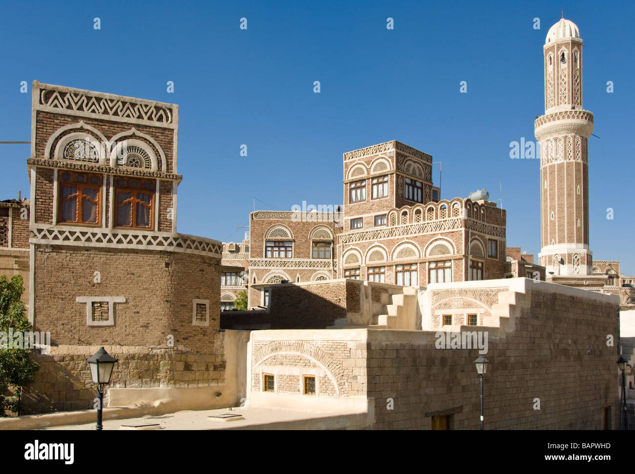 Edificio tradizionale con moschea nel quartiere del centro storico di Sana'a, Yemen Foto Stock